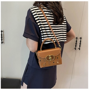 Bolso bandolera marrón vintage con broche dorado ovalado y textura de cuero retro