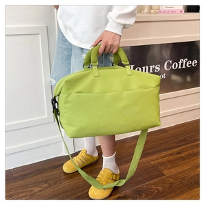 Detail view of large fruit green travel bag with comfortable handles and storage pockets
