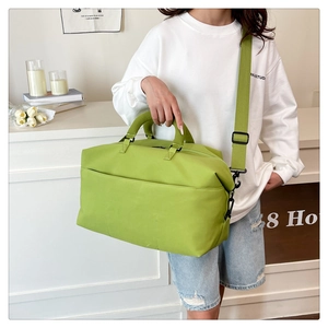 Detail view of avocado green travel bag with waterproof nylon texture and black metal hooks