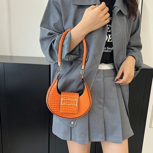 Borsa a mezzaluna arancione effetto coccodrillo con fibbia dorata indossata da una modella