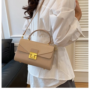 Dettaglio borsa a tracolla beige con patta intrecciata e chiusura a scatto dorata