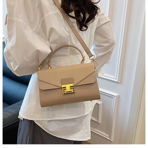 Dettaglio borsa a tracolla beige con patta intrecciata e chiusura in metallo dorato