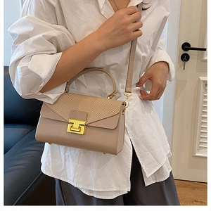 Dettaglio elegante borsa beige a tracolla con tessuto a contrasto e fibbia dorata