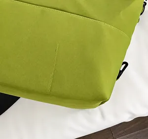 Détail macro des coutures de précision sur le tissu vert résistant à l'eau du sac