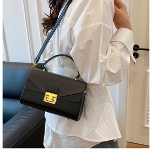 Dettaglio borsa a scatola in pelle nera con patta testurizzata e fibbia dorata elegante