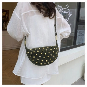Detail view of dark green suede hobo bag with gold rivets and adjustable strap