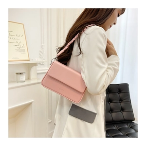 Détail du sac boîte rose avec bandoulière tressée et lettrage doré estampé à chaud