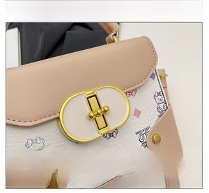 Detalle del cierre de metal dorado y estampado de osos en el bolso bandolera beige