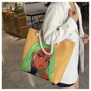 Detail of yellow canvas tote bag with bold figure print and thick white cotton rope handles
