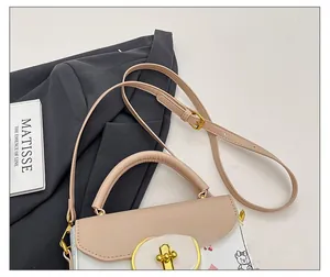 Detalle de la correa rosa ajustable y hebilla dorada en el bolso blanco con estampado