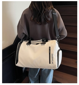 Bolsa de viaje beige grande con correas negras llevada al hombro por una persona
