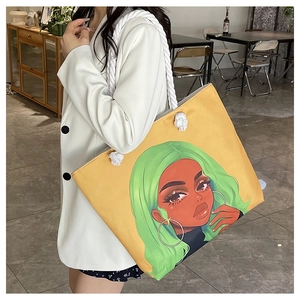 Detail of yellow canvas tote bag with thick white rope handles and green-haired girl print