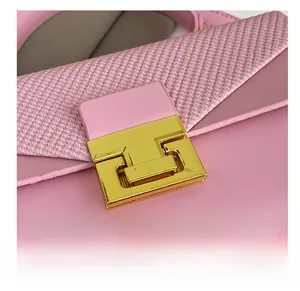 Dettaglio della fibbia in metallo dorato e della trama intrecciata rosa della borsa
