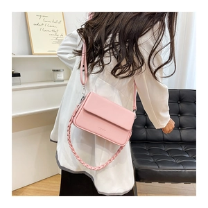 Vue détaillée du sac bandoulière rose avec poignée tressée et rabat aimanté