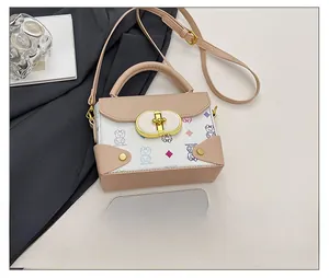 Detalle del tamaño del bolso pequeño beige comparado con un smartphone y cierre dorado