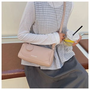 Detail of nude pink cylinder crossbody bag in lychee pattern leather for women