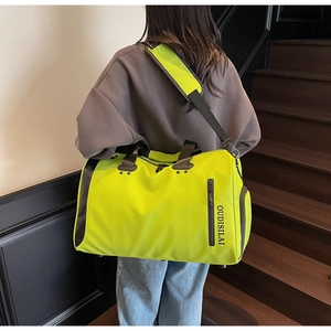 Detalle de bolsa deportiva amarillo neón con correa acolchada y logo en tejido denso