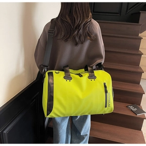 Detalle de la bolsa de viaje amarillo neón con nailon impermeable y correa de hombro