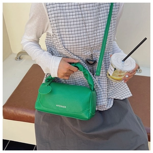 Close-up of green pebble leather Boston bag with pleated handle and MIFEIKAER logo
