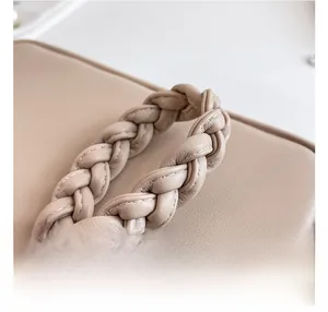 Détail du sac en cuir beige de qualité avec une poignée tressée épaisse et élégante