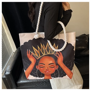Detail showing printed black girl graphic with crown on canvas tote bag with thick rope handles