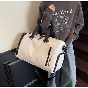Primer plano de bolsa de viaje crema con correas negras y logo OUDISILAI