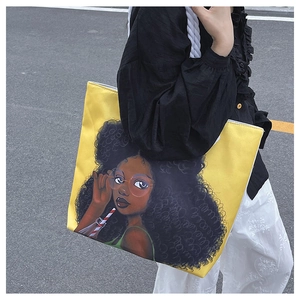 Detail of yellow tote bag featuring a black girl illustration and thick rope handles