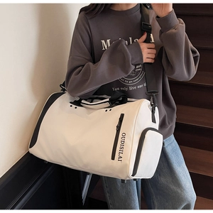 Mujer lleva bolsa de viaje grande con separación en seco y húmedo para fitness y deporte