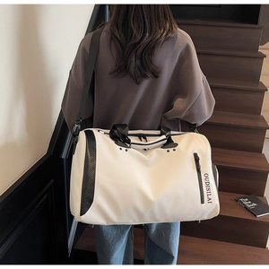 Detalle de bolsa de viaje de gran capacidad con textura de carbono y correa ajustable