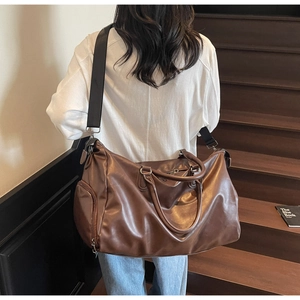 Brown vintage travel bag detail on shoulder of model showing texture and strap