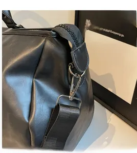 Detail of gunmetal gray metal hook and reinforced stitching on black travel bag