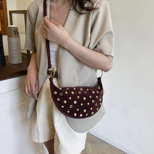 Burgundy suede crescent shoulder bag with gold studs and rivets in bohemian style