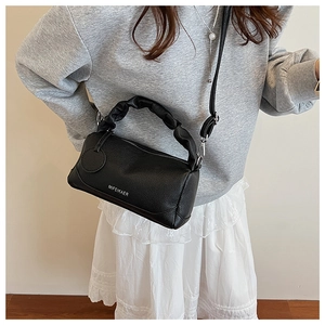 Close-up of black litchi grain leather bag with soft pleated handle and metal zipper detail