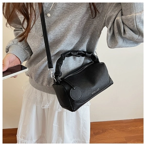 Close-up of black lychee texture leather Boston bag with cloud-shaped ruched handle details