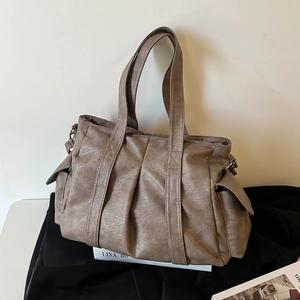 Minimalist taupe oversized tote bag with pleated texture and side flap pockets