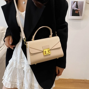 Elegante borsa a mano beige con chiusura a scatto dorata e tracolla su modella