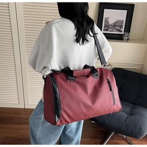 Detalle de bolsa de viaje granate con tela impermeable y textura de fibra de carbono