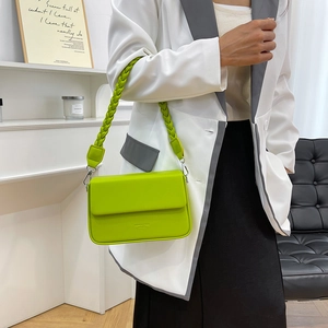 Sac boîte rétro vert fluo avec bandoulière tressée porté par un mannequin