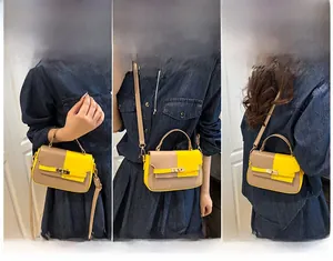 Three-way carry display of a dual-color Kelly bag with crossbody and handheld options