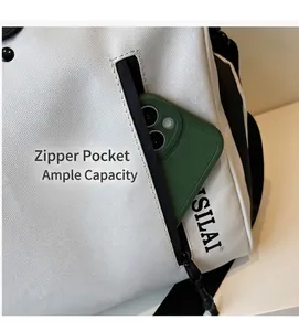 Detail view of the white travel bag showing front zipper pocket for smartphone storage