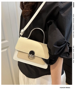 Close-up of a contrasting straw-weave and white leather handbag with silver metal lock