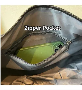 Interior detail of travel bag showing a grey fabric lining and a metal zippered pocket