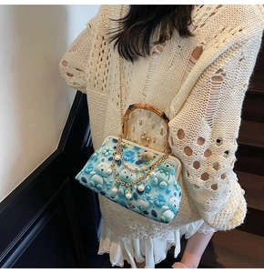 Detail of bamboo handle and 3D bear floral pattern on light blue vintage clutch bag