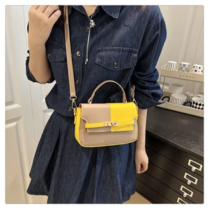 Detail showing the contrast beige and yellow leather with a metal twist lock closure