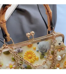 Close-up of vintage gold hardware and bamboo handle on the cute bear embroidery bag