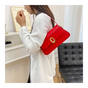 Chic red rectangular shoulder bag with gold oval clasp shown on a shoulder
