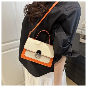 Close-up of orange and beige woven patchwork handbag with a silver metal clasp