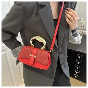 Detail der roten Pailletten-Handtasche mit H-Schnalle und goldenem Griff am Model