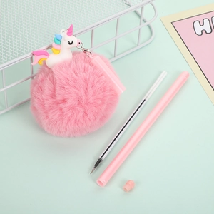 Pink plush unicorn ballpoint pen with fluffy pom pom and spare refill on green background