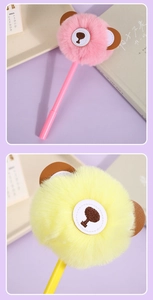 Close-up of cute cartoon bear plush ball pens in pink and yellow colors for writing